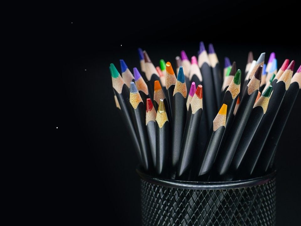 A row of sharpened yellow pencils lying on a sheet of lined paper beside a folded letter